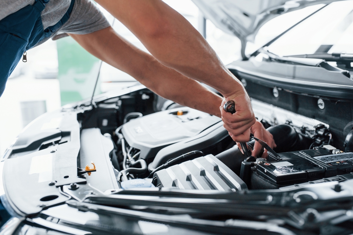 mec&acirc;nico verificando bateria automotiva